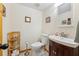 Cozy half bathroom featuring wood vanity with white sink, a toilet, and neutral colored walls at 702 Glasgow Ct, Winter Springs, FL 32708