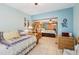 Cozy bedroom featuring light blue walls, tile flooring, daybed, and wicker furniture at 702 Glasgow Ct, Winter Springs, FL 32708