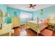 Cheerful bedroom with turquoise walls, hardwood floors, and bright yellow furniture and pineapple accents at 702 Glasgow Ct, Winter Springs, FL 32708