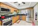 Well-lit kitchen with stainless steel appliances, granite countertops, and light wood cabinets at 702 Glasgow Ct, Winter Springs, FL 32708