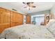 Bedroom features a wooden sliding door, wooden closets, ceiling fan, and entry to another bedroom at 702 Glasgow Ct, Winter Springs, FL 32708