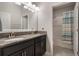 Bathroom featuring a double vanity with dark cabinets and a granite countertop, with an open view to a tub/shower combo at 7605 Lake Hancock Blvd, Winter Garden, FL 34787