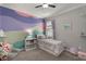 This bedroom is decorated with a pastel, cloud-painted wall, complemented by soft furnishings in harmonious hues at 7605 Lake Hancock Blvd, Winter Garden, FL 34787