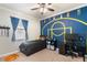 A cozy bedroom featuring a basketball court painted on the wall with a ceiling fan and neutral-toned carpet at 7605 Lake Hancock Blvd, Winter Garden, FL 34787