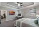 Primary bedroom with tray ceiling, tv, workstation, and a large window at 7605 Lake Hancock Blvd, Winter Garden, FL 34787