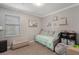 Bedroom with a daybed with a seafoam-colored comforter, along with a grey cushioned ottoman and built-in storage at 7605 Lake Hancock Blvd, Winter Garden, FL 34787