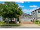 Charming home featuring a well-manicured lawn, a stone facade, and a two-car garage with a brick driveway at 7605 Lake Hancock Blvd, Winter Garden, FL 34787