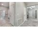 Hallway featuring tile flooring, neutral paint, and a view of the bathroom, entryway and a coat rack at 7605 Lake Hancock Blvd, Winter Garden, FL 34787