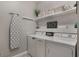 Well-organized laundry room with washer, dryer, shelves, and ironing board at 7605 Lake Hancock Blvd, Winter Garden, FL 34787