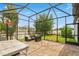 Spacious screened patio with brick pavers and a view of the backyard with comfortable outdoor furniture at 7605 Lake Hancock Blvd, Winter Garden, FL 34787