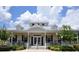 Community clubhouse exterior with white siding, covered front porch, and symmetrical landscaping at 8031 Enchantment Dr # Ge, Windermere, FL 34786