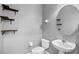 Modern powder room with pedestal sink, floating shelves and a round mirror at 8031 Enchantment Dr # Ge, Windermere, FL 34786