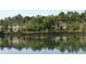 View of a line of townhomes with lush landscaping reflected in a calm pond at 8031 Enchantment Dr # Ge, Windermere, FL 34786