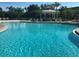 Community pool with clear blue water, lounge chairs, palm trees, and a gazebo at 8031 Enchantment Dr # Ge, Windermere, FL 34786