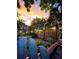 Tranquil backyard oasis with lush landscaping, a wooden fence, and string lights under a sunset at 806 E Amelia St, Orlando, FL 32803