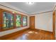 Bright bedroom featuring hardwood floors, natural wood trim, and large windows overlooking lush landscaping at 806 E Amelia St, Orlando, FL 32803