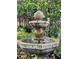 Close up of a three-tiered fountain with lush landscaping, adding a touch of elegance to the yard at 806 E Amelia St, Orlando, FL 32803