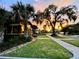 Beautiful craftsman home with mature trees and lush landscaping under a vibrant sunset sky at 806 E Amelia St, Orlando, FL 32803