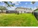Large, grassy backyard with screened pool enclosure, patio seating and fenced perimeter at 812 Seneca Meadows Rd, Winter Springs, FL 32708