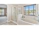 Relaxing bathroom with a glass-enclosed shower and soaking tub, complemented by a bright window at 812 Seneca Meadows Rd, Winter Springs, FL 32708