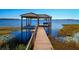 Picturesque lake dock and boat lift featuring a quaint, covered sitting area at 8250 Cherry Lake Rd, Groveland, FL 34736