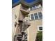 Tan home exterior featuring spiral staircase leading to an upper level balcony at 8250 Cherry Lake Rd, Groveland, FL 34736