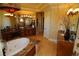 Luxury bathroom featuring a soaking tub, granite counters, custom cabinets, and ample space at 8250 Cherry Lake Rd, Groveland, FL 34736