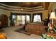 Comfortable main bedroom featuring a tray ceiling and an exterior access door at 8250 Cherry Lake Rd, Groveland, FL 34736
