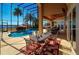Screened in patio area featuring a luxurious pool and an outdoor dining area with lake views at 8250 Cherry Lake Rd, Groveland, FL 34736
