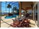 Screened in patio area featuring a luxurious pool and an outdoor dining area with lake views at 8250 Cherry Lake Rd, Groveland, FL 34736