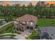 Aerial view of luxury home featuring a tile roof, lush landscaping, and serene lake views at 8478 Elba Isle Ct, Windermere, FL 34786