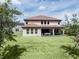 Expansive backyard featuring lush lawn, covered patio, and a view of the home's exterior at 8478 Elba Isle Ct, Windermere, FL 34786