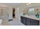 Bright bathroom with a glass-enclosed shower, double vanity, and walk-in closet with custom shelving at 8478 Elba Isle Ct, Windermere, FL 34786