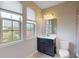 Bright bathroom features a dark vanity, white counter, and window with neighborhood views at 8478 Elba Isle Ct, Windermere, FL 34786