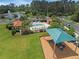Aerial view of community pool, playground, and nearby pond surrounded by trees at 8478 Elba Isle Ct, Windermere, FL 34786