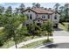 Beautiful two-story home featuring stone accents, lush landscaping, and a charming front porch and three-car garage at 8478 Elba Isle Ct, Windermere, FL 34786