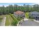 Aerial view of a two-story home with a tile roof, lush landscaping, a three-car garage and a pond at 8478 Elba Isle Ct, Windermere, FL 34786