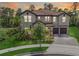 Gorgeous front exterior with a tile roof, stone accents, lush landscaping, and three-car garage at 8478 Elba Isle Ct, Windermere, FL 34786
