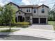 Charming two-story home showcasing a tile roof, stone accents, lush landscaping, and a three-car garage at 8478 Elba Isle Ct, Windermere, FL 34786