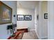 Upstairs hallway with art, console table, and access to rooms with neutral color palettes at 8478 Elba Isle Ct, Windermere, FL 34786