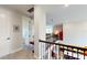 Upstairs hallway with access to bedrooms, open recreation areas, and a view to the downstairs kitchen at 8478 Elba Isle Ct, Windermere, FL 34786