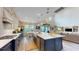 Spacious kitchen features a large island with white countertops, stylish pendant lights, and stainless steel appliances at 8478 Elba Isle Ct, Windermere, FL 34786