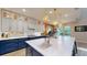 Stylish kitchen featuring custom cabinets, a large island with a sink, and modern pendant lighting at 8478 Elba Isle Ct, Windermere, FL 34786