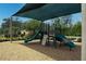 Community playground with slides and climbing features is sheltered by a canopy near a pool at 8478 Elba Isle Ct, Windermere, FL 34786
