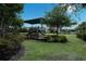 Community playground nestled amongst trees, featuring shaded play area, bench seating, and well-maintained landscaping at 8478 Elba Isle Ct, Windermere, FL 34786