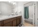 Bright bathroom features double sink vanity with white countertops and shower with tile surround at 849 Avenal Ln, Davenport, FL 33837