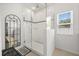 Bathroom showcasing a glass-enclosed shower with white tiles and decorative mirror at 849 Avenal Ln, Davenport, FL 33837