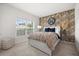 Bright bedroom with a stylish accent wall, large window and a comfortable queen size bed at 849 Avenal Ln, Davenport, FL 33837
