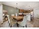 Open dining space with a rustic table, modern lighting, and convenient access to the kitchen area at 849 Avenal Ln, Davenport, FL 33837