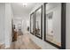 Bright hallway with wood floors, white walls, and decorative mirrors leading to other rooms at 849 Avenal Ln, Davenport, FL 33837